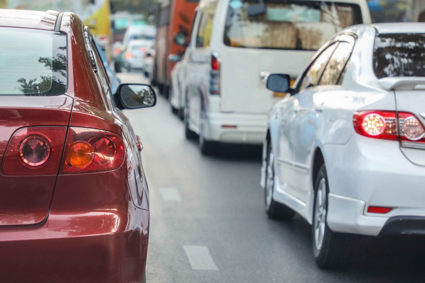 close-up-red-car-stuck-traffic-jam.jpg