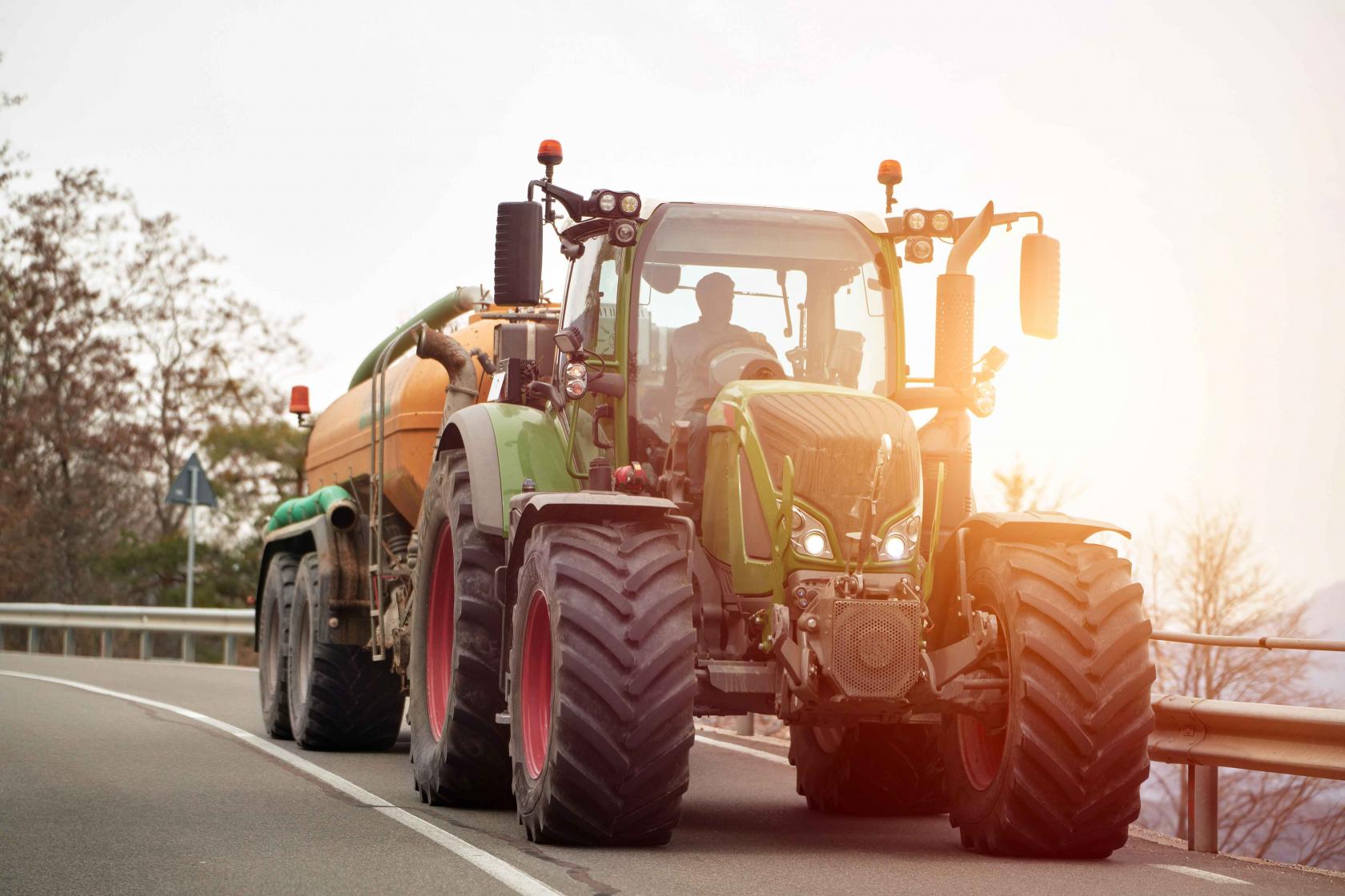 farm-tractor-moving-rural-road-near-farm-agricultural-efforts-motion-tractor-work-sunny-spring-day.jpg