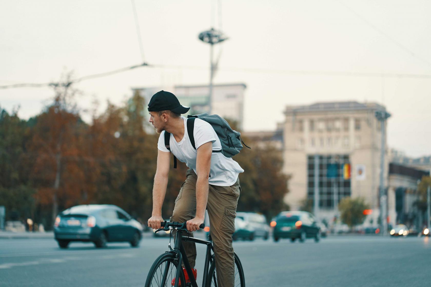 man-riding-bicycle-urban-city-holding-hands-handlebar.jpg